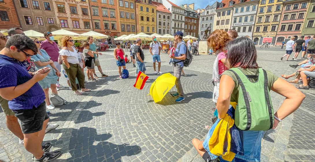 Guided tour group in Warsaw's Old Town Square.