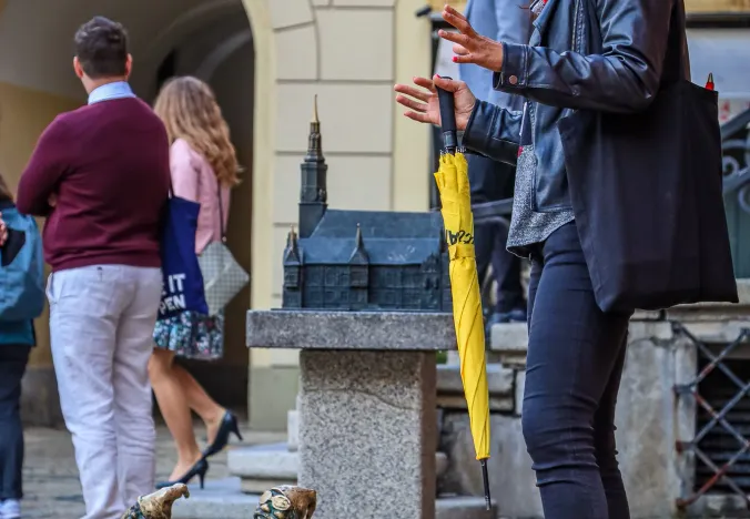 A tour guide in Wroclaw, Poland, points out dwarf statues to a group of tourists.
