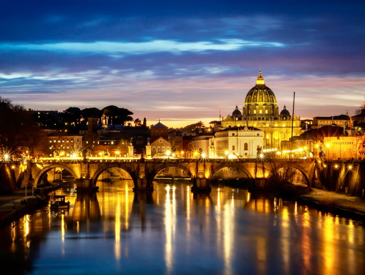 Sunset over the St. Peter's Basilica and Tiber River in Rome.