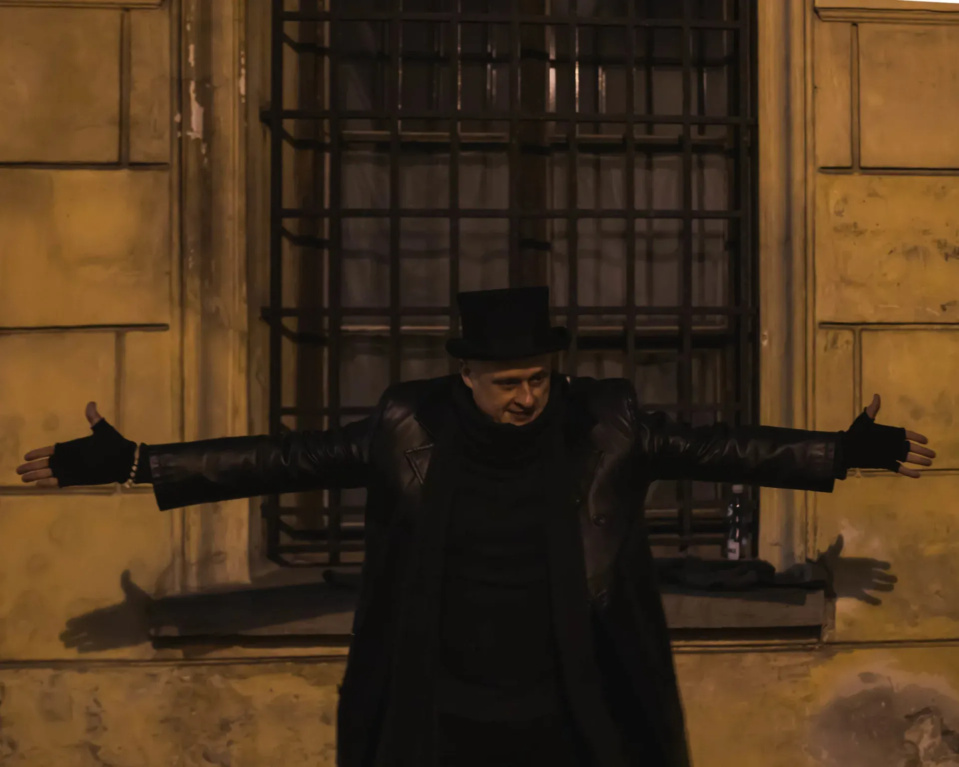 Tour guide in top hat in front of old building.