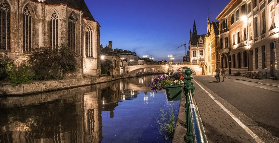 Charming canal in Bruges at night, reflecting the city's medieval architecture.