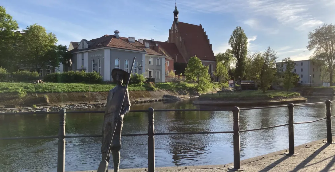 A bronze statue by a canal in Bydgoszcz's Old Town, Poland.