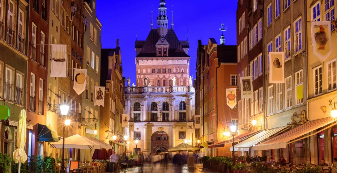 Night view of Gdansk's Golden Gate and Długi Targ street.