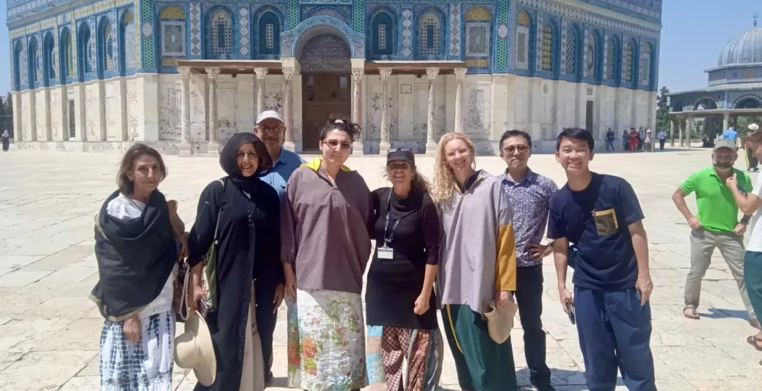 Happy tourists on a guided tour in front of the Dome of the Rock in Jerusalem.