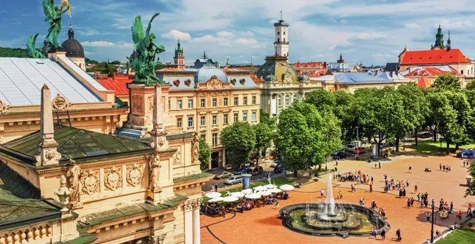 Tourists enjoying a sunny day in Lviv's city center square.