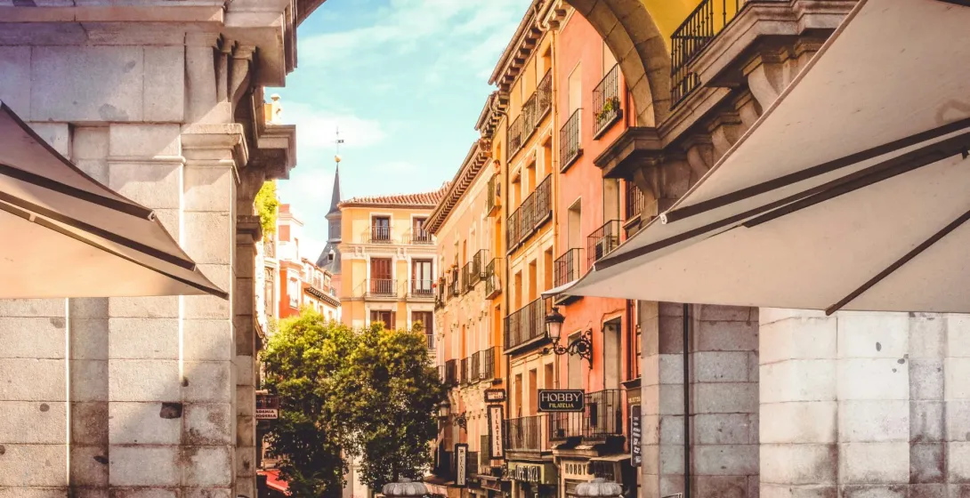 Charming street view in Madrid, Spain, seen through an archway.