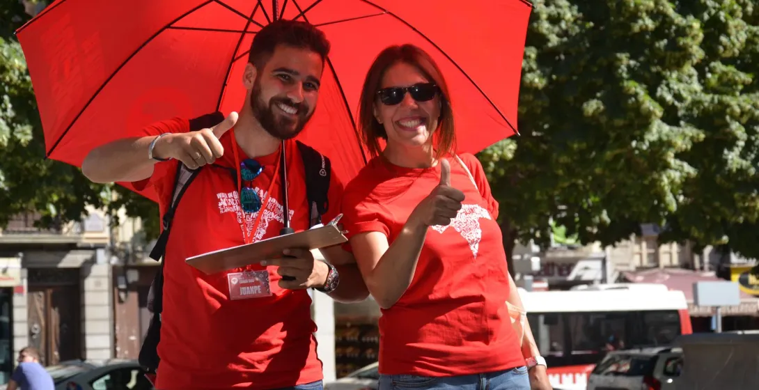 Two smiling tour guides in Madrid give thumbs up.