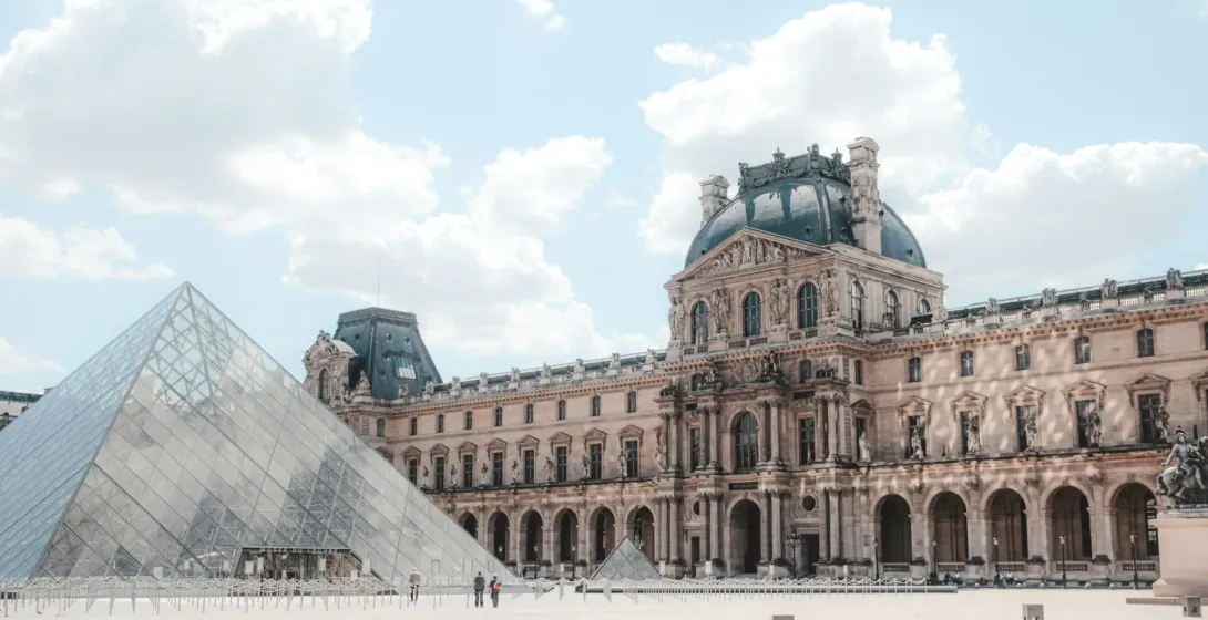 The Louvre Museum in Paris, featuring its iconic glass pyramid and classical architecture.