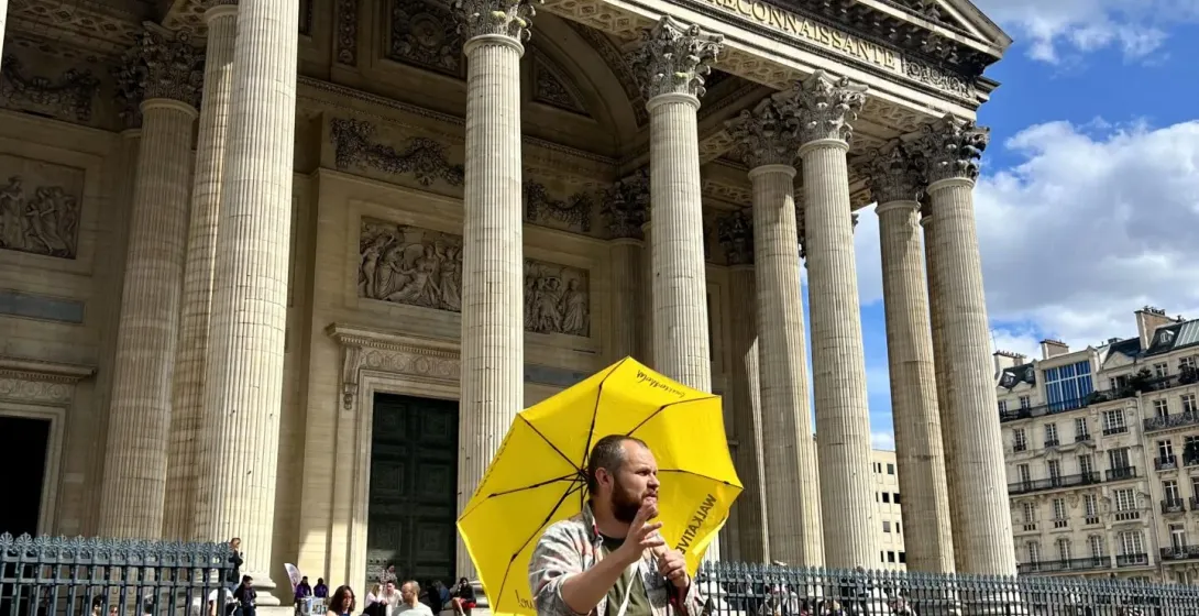 A tour guide leads a group through the Latin Quarter in Paris, showcasing the Panthéon.