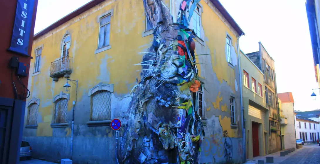 A giant rabbit sculpture made of recycled materials stands on a street corner in Vila Nova de Gaia, Porto.
