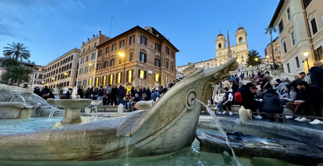 Tourists gather around the Barcaccia Fountain at the foot of the Spanish Steps in Rome, Italy.