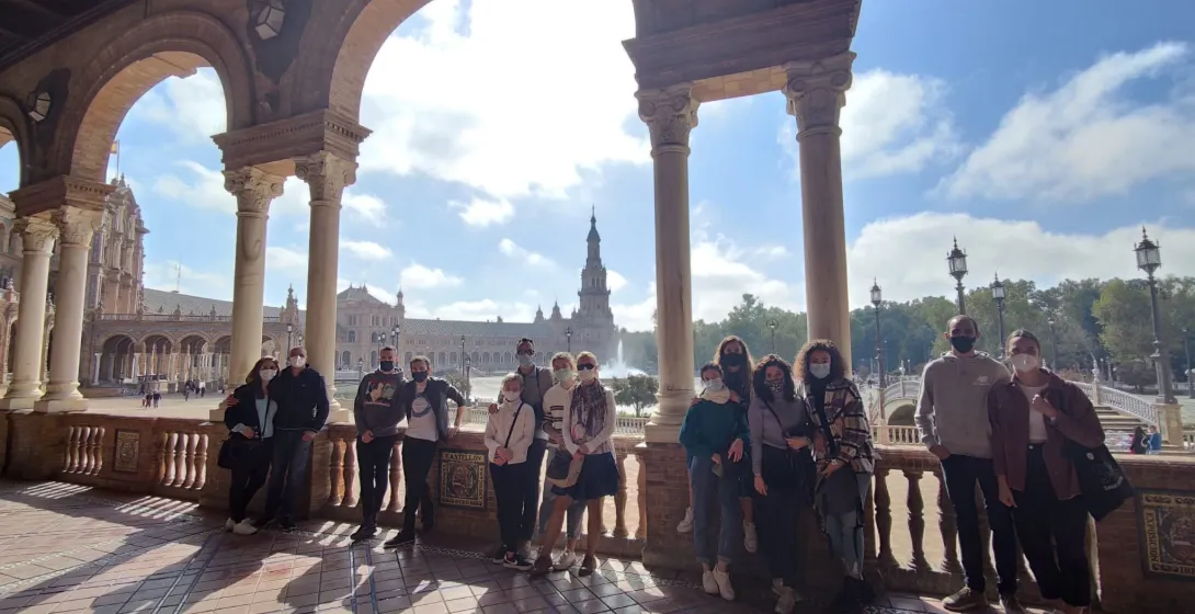 A tour group smiles in Seville's Plaza de España.