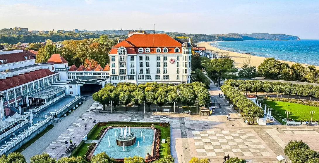 Aerial view of Sopot's Grand Hotel, beach, and fountain.