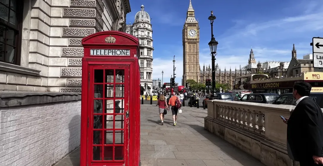 Iconic London scene: red phone booth, Big Ben, and Houses of Parliament.