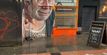 A large street art mural of a man's face in Glasgow.