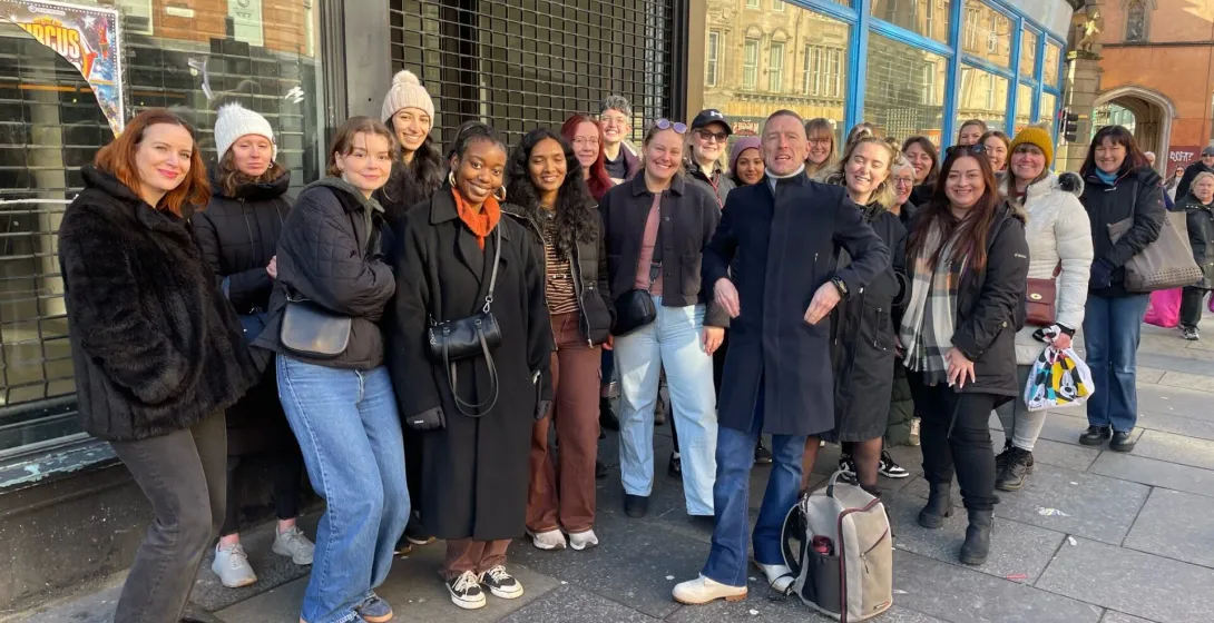 A large tour group enjoys a walking tour in Glasgow, Scotland.