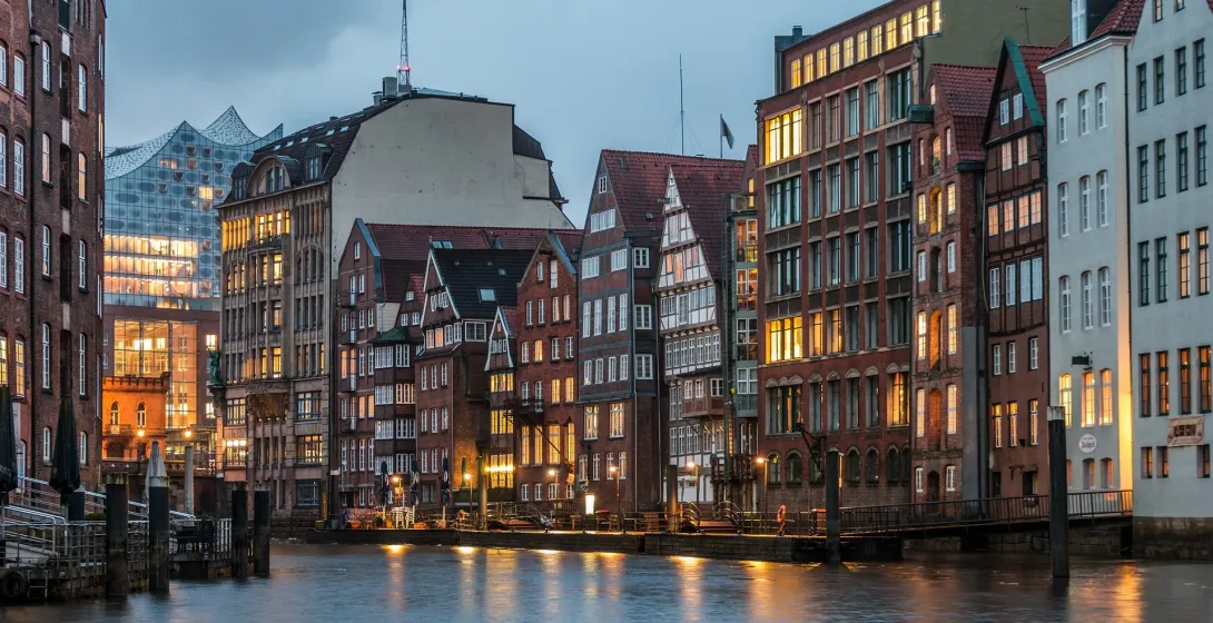Historic Hamburg Speicherstadt at night, illuminated buildings reflected in the canal.
