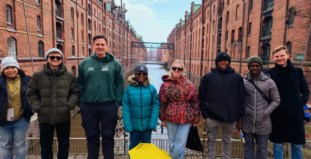 Happy tourists on a guided tour in Hamburg's Speicherstadt.