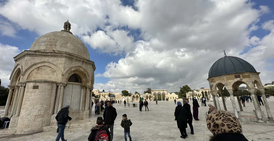 Visitors explore the Temple Mount in Jerusalem, admiring the historical domes and architecture.