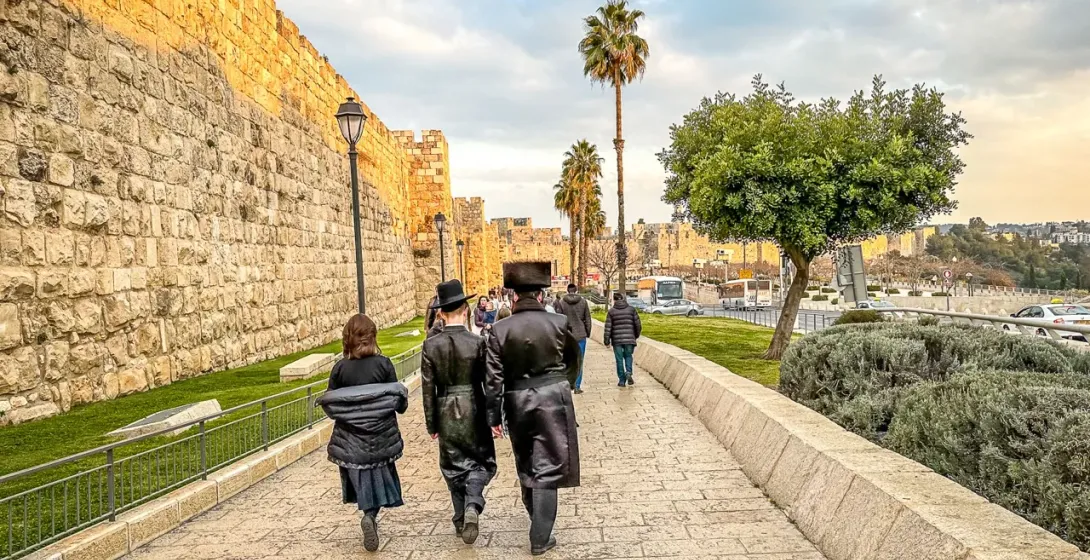 Tourists walking along the ancient Jerusalem city walls.