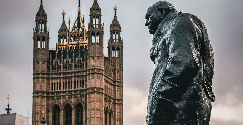 Statue of Winston Churchill with the Palace of Westminster in the background in London.