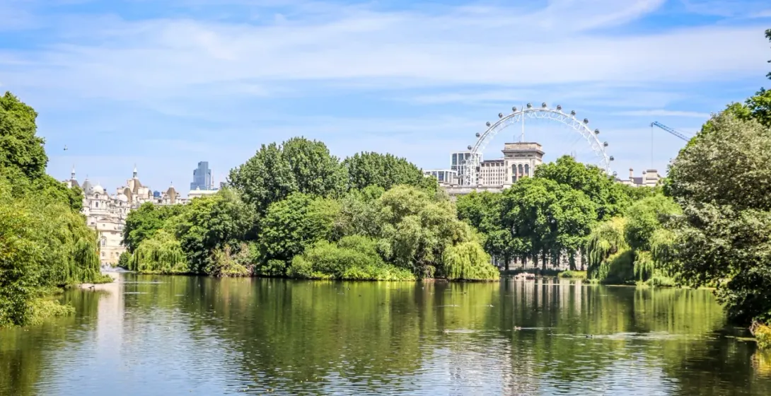 Serene view of St. James's Park in London, with the London Eye in the distance.