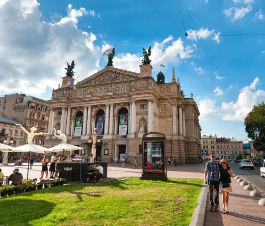 Tourists enjoying the sunny square in front of the magnificent Lviv Opera House in Ukraine.