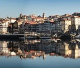 Panoramic view of Porto's Ribeira district reflected in the Douro River.