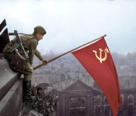 Soviet soldier raising a flag in war-torn Berlin.