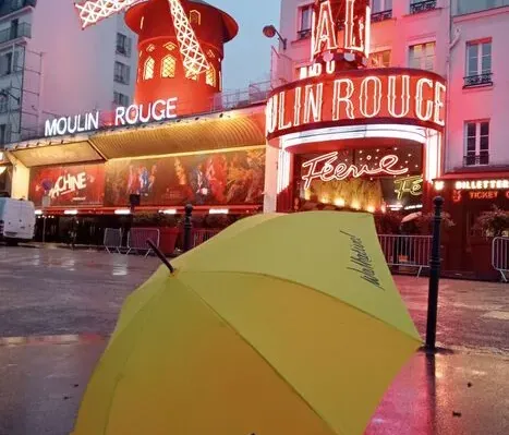 Walkative! tour guide umbrella in front of the Moulin Rouge in Paris.