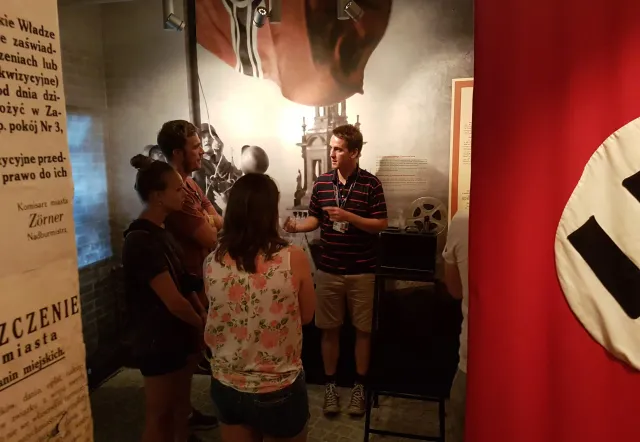 Tour group listening to guide in a museum exhibit.