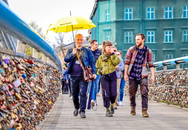 A Walkative tour group explores Krakow, Poland, walking across a bridge covered in love locks.