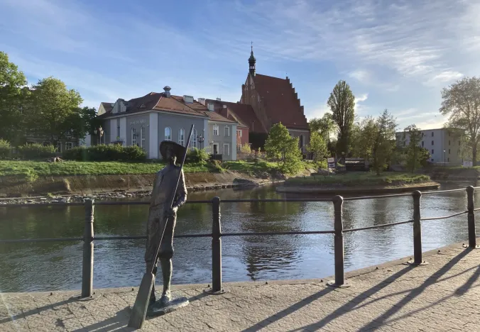 A bronze statue by a canal in Bydgoszcz's Old Town, Poland.