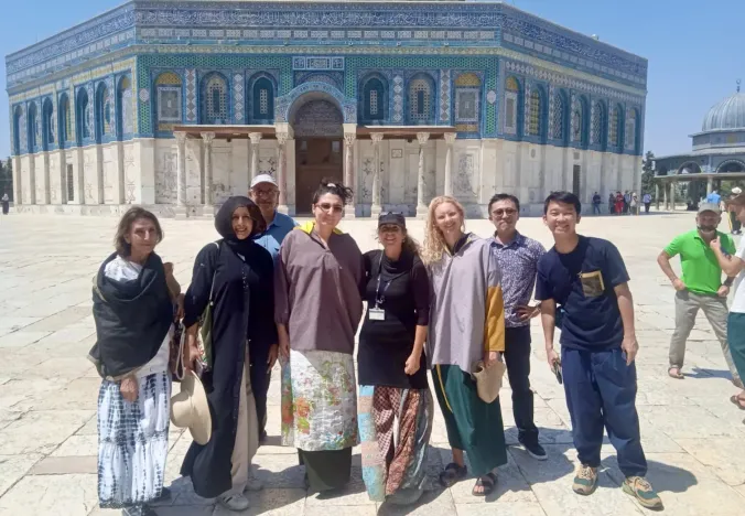 Happy tourists on a guided tour in front of the Dome of the Rock in Jerusalem.