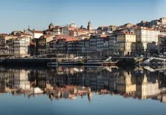 Panoramic view of Porto's Ribeira district reflected in the Douro River.