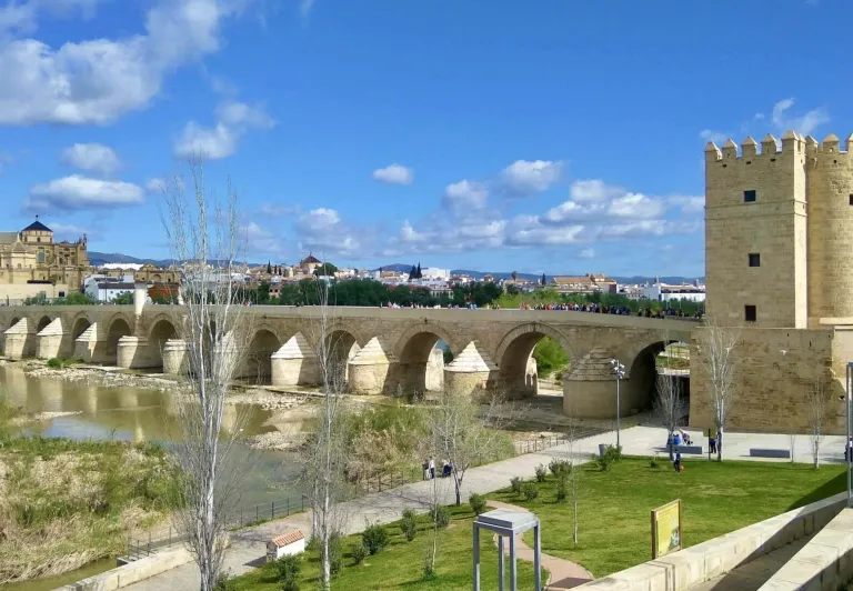 Tourists on the Roman Bridge in Cordoba, Spain, with the Mezquita-Cathedral in the background.