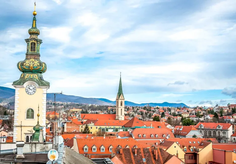 Panoramic view of Maribor, Slovenia, featuring a prominent clock tower and terracotta rooftops.