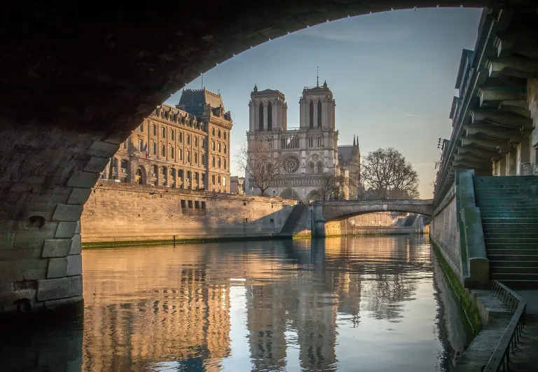 Stunning view of Notre Dame Cathedral in Paris, reflected in the Seine River.