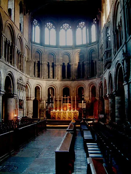 View towards the candlelit high altar and Romanesque apse inside London's St. Bartholomew the Great church.