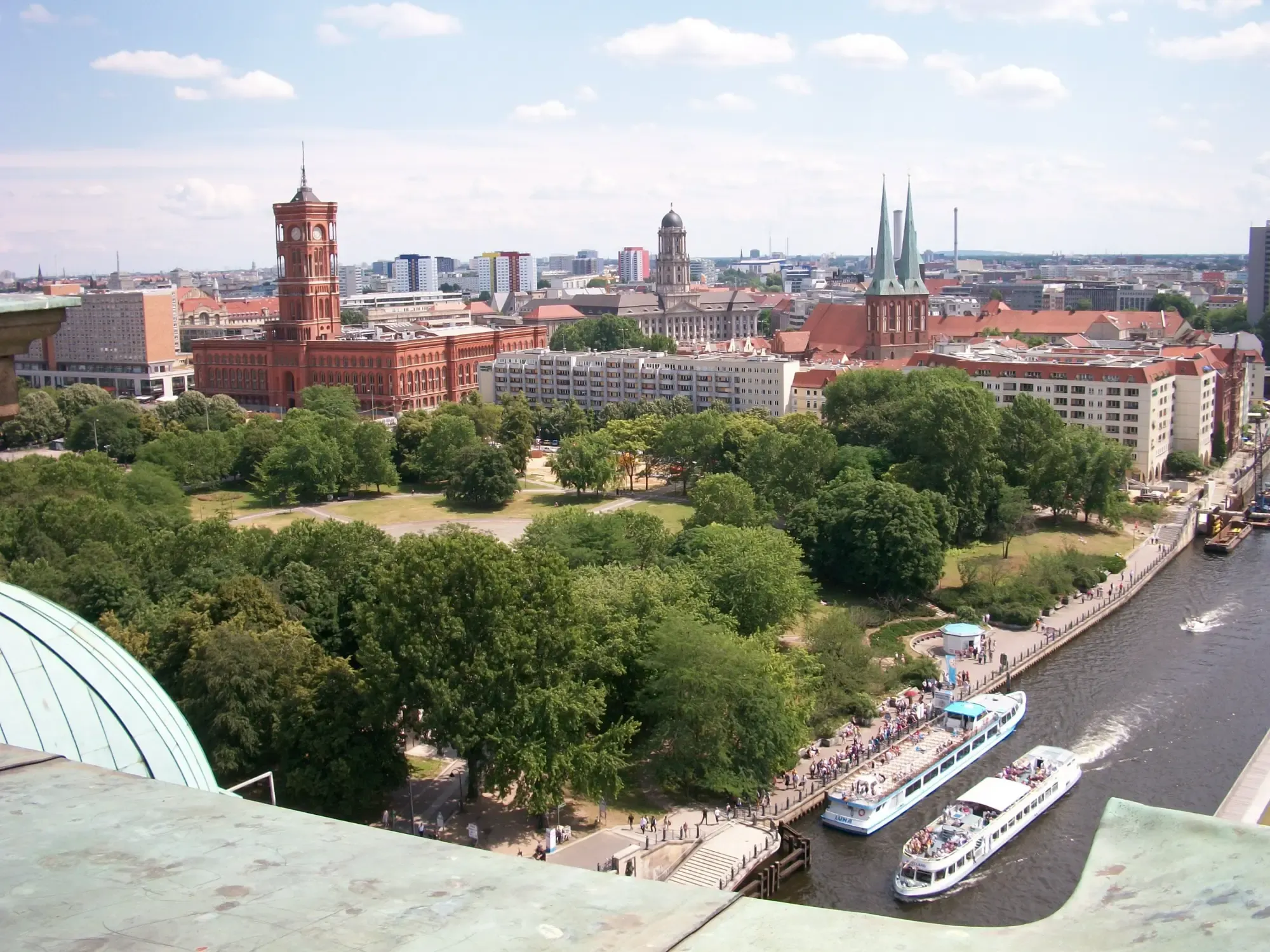 Aerial view of Berlin showing the Rotes Rathaus, Spree River with tour boats, and Nikolaikirche.