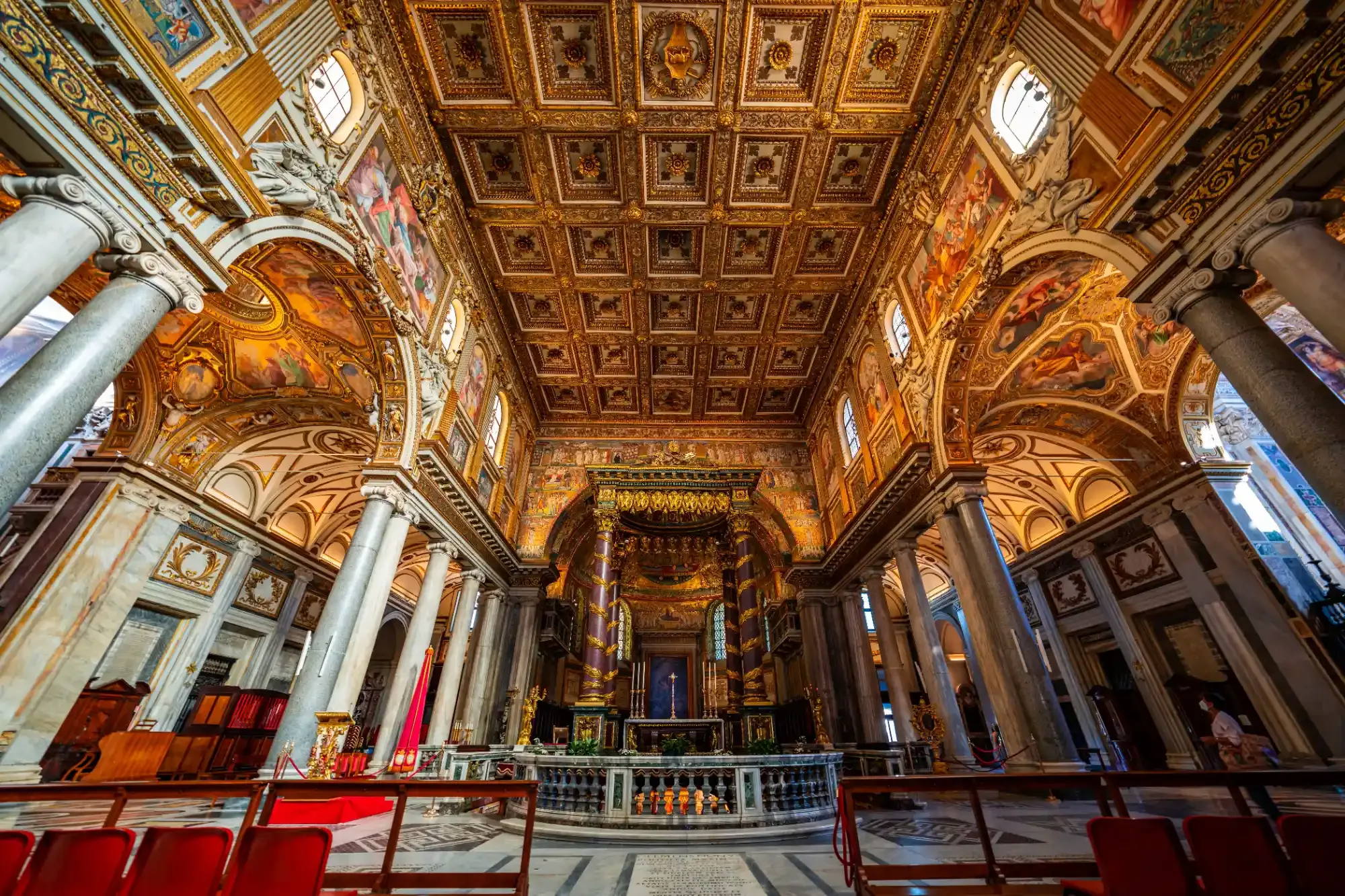 Gilded coffered ceiling and ornate main altar inside the Basilica of Santa Maria Maggiore in Rome.