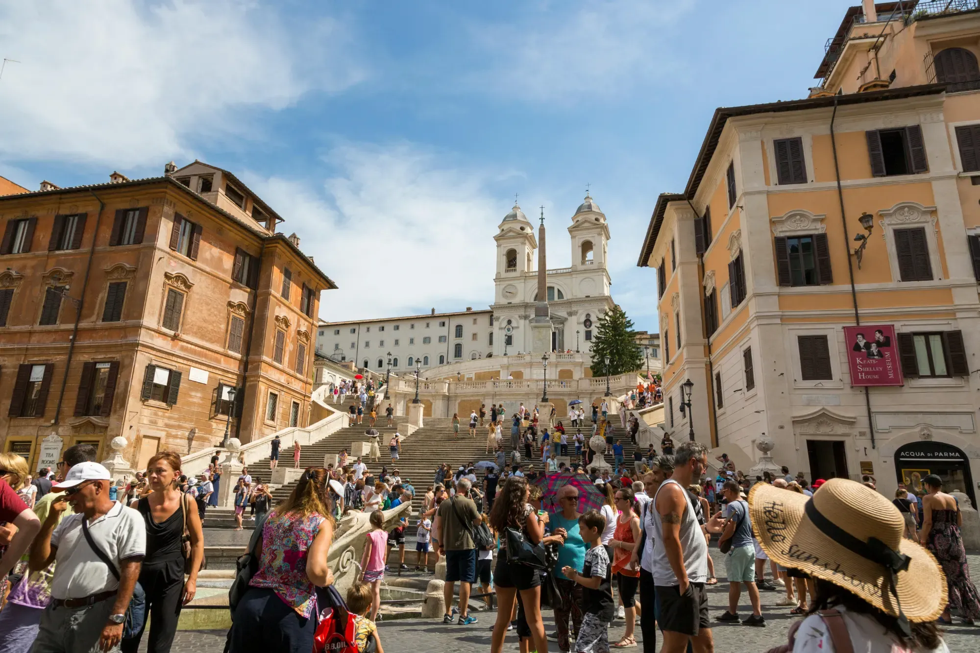 Crowds of tourists gathered at the historic Spanish Steps in Rome, leading up to the Trinità dei Monti church.