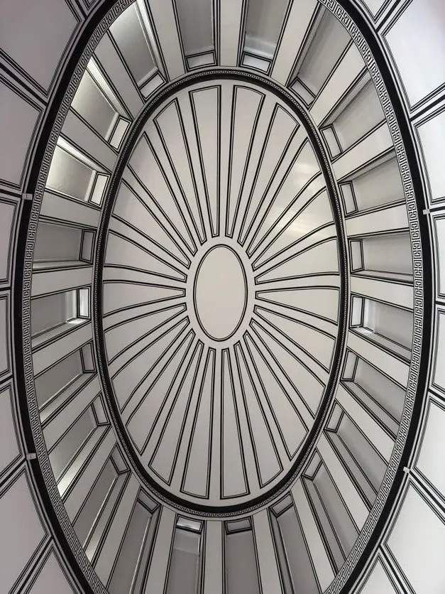White oval ceiling with radiating black lines, a central oval, and rectangular panels creating an optical illusion of depth.