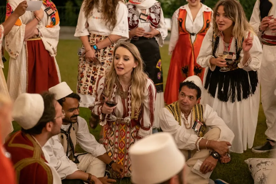 Tourists in traditional Albanian clothing enjoy an evening event.