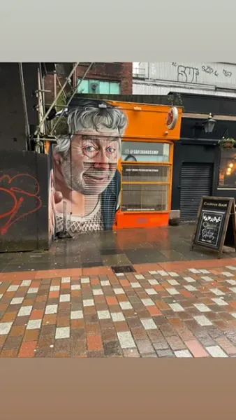 A large street art mural of a man's face in Glasgow.