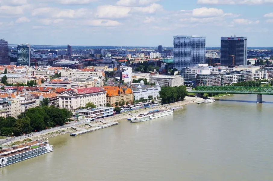 Panoramic view of Bratislava, Slovakia, with river cruise ships on the Danube River.