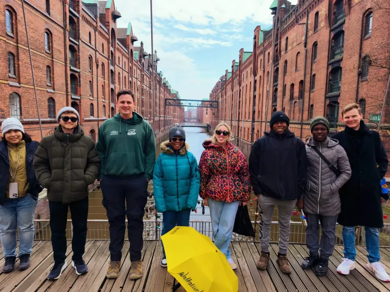 Happy tourists on a guided tour in Hamburg's Speicherstadt.