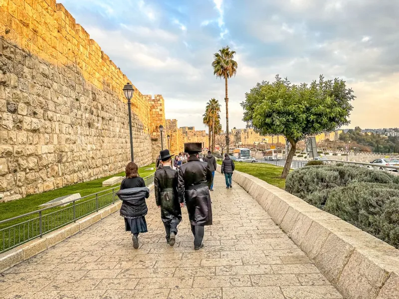 Tourists walking along the ancient Jerusalem city walls.