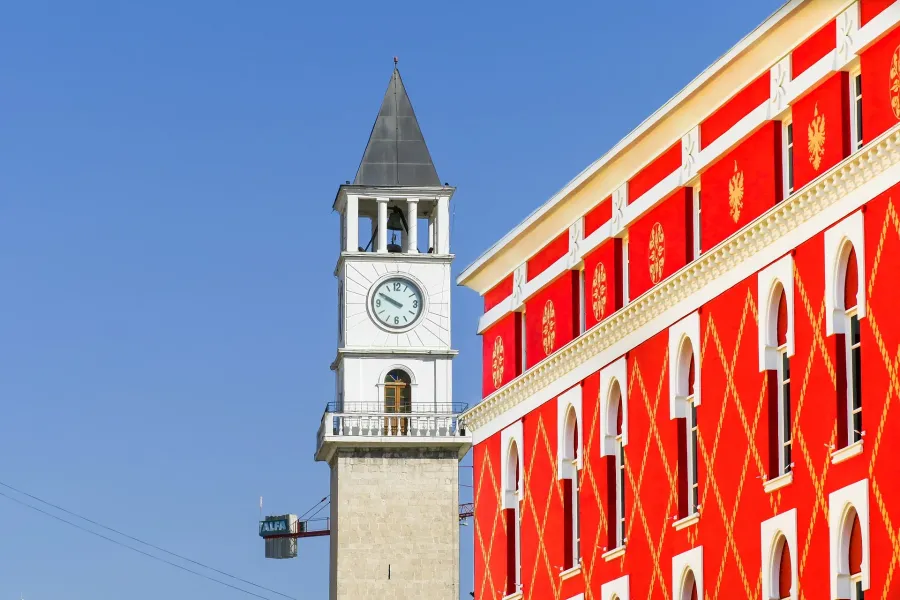 Tirana's Clock Tower and a vibrant building in the historic center.