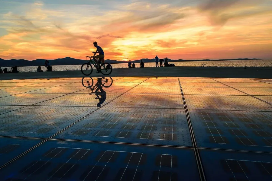 Cyclist at sunset on Greeting to the Sun, Zadar